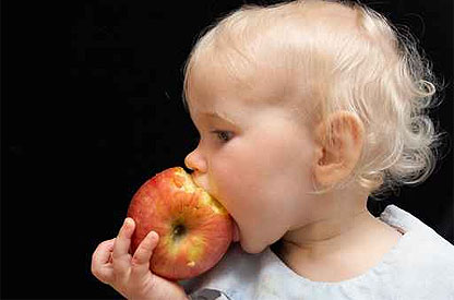 Kleinkind beißt in einen Apfel